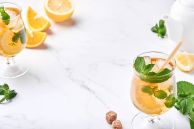 Geleneksel buzlu çay, limon ve buzlu uzun bardaklarda mermer masa üzerinde buzlu limonlu çay. Seçici odaklanma. Soğuk yaz içeceği..