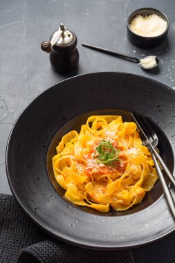 Geleneksel İtalyan Passat soslu Fettuccine makarna ve beyaz arka planda hafif tabakta parmesan peyniri. Üst görünüm.