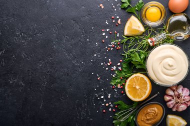 Ev yapımı mayonez sosu ve limon, yumurta, zeytinyağı, baharat ve otlar, siyah arka plan fotokopi alanı. Yemek pişirme geçmişi. Üst görünüm.