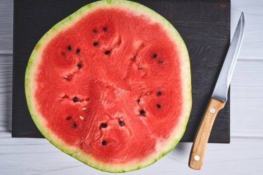 Sliced watermelon on a black cutting board. Mock up for design. Copy space.