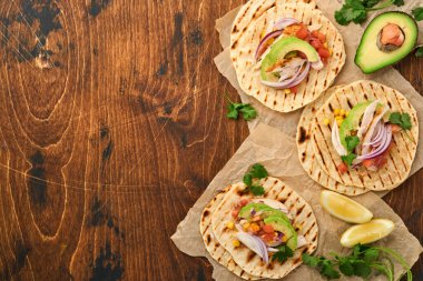 Izgara tavuk, avokado, mısır taneleri, domates, soğan, kişniş ve eski ahşap salsa masalı Meksika tacoları. Geleneksel Meksika ve Latin Amerika sokak yemekleri. Üst görünüm.