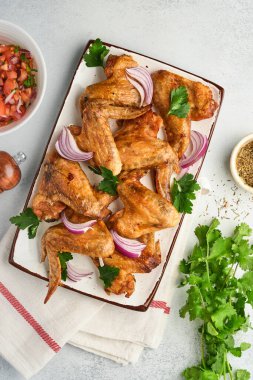 Izgara tavuk kanadı ya da açık gri kayrak, taş ya da beton zemin üzerinde baharat ve domates soslu kızarmış bbq. Kopyalama alanı olan üst görünüm.