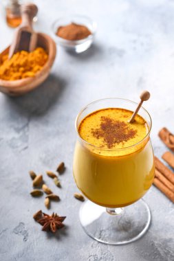 Tarçın çubukları ve ballı zerdeçal altın sütlü latte. Sağlıklı ayurvedic içki. Vejetaryenler için baharatlı Asya doğal detoks içeceği. Boşluğu kopyala.