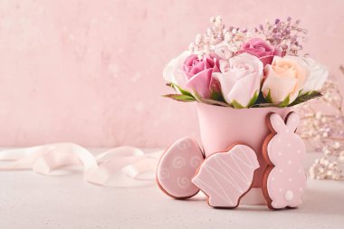 Paskalya arkaplan süslemesi, vazoda pembe güller, paskalya yumurtaları, pembe arka plan masasında tavşanlar ve piliçler. Kopya alanı ile Paskalya kavramı.