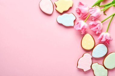 Paskalya zencefilli yumurtalı pembe laleler pembe arka planda yer alıyor. Çiçek deseni. Model yap ve afiş yap. Metin için boşluk.