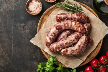 Çiğ sosis ya da parşömen kağıdına sosis ve yemek malzemesi. Taş tablo üzerinde kopyalama alanı olan üst görünüm.