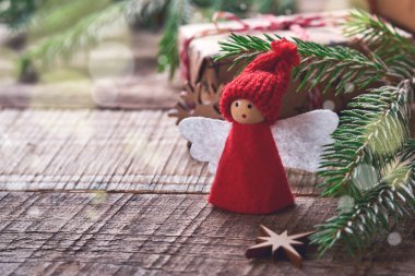 Komik Noel Meleği ağaç dalları ve karlı arka planda karlı dalları olan hediye kutuları. Noel veya Kış konsepti.