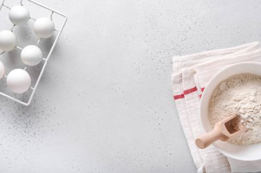 Ev yapımı pişirme malzemesi. Beyaz mermer masa üzerinde un, yumurta, mutfak aletleri, kap kacak ve kurabiye kalıpları ile fırın arka planı. Üst Manzara. Düz yatış stili. Model.