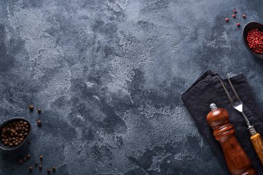 Eski et çatalı, boş ahşap tezgah, eski gri beton arka planda kara biber ve karabiber ve baharat değirmeni. Yemek pişirme arka planı ve maketi.