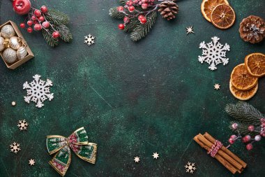 Noel ağacı dalları, Noel baloları, hediye kutuları, ahşap kar taneleri ve yeşil betondan arkaplan yıldızları Noel kutlamalarınız için. Kopyalama alanı olan üst görünüm. Noel tebrik kartı..