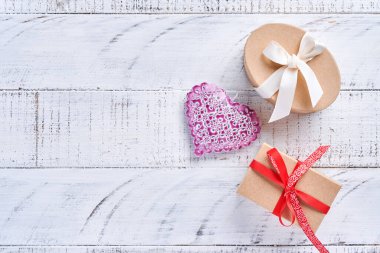 Beyaz tahta duvarın önünde el yapımı pembe kalplerle Sevgililer Günü tebrik kartı. Üst görünüm.