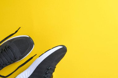 Sarı arka planda siyah erkek ayakkabıları. Moda blogu ya da dergi konsepti. Erkek ayakkabıları, moda spor ayakkabıları, moda, yaşam tarzı. Model yap. Düz görünüm kopyalama alanı en az arkaplan.