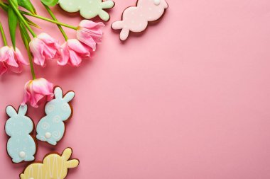 Paskalya zencefilli yumurtalı pembe laleler pembe arka planda yer alıyor. Çiçek deseni. Model yap ve afiş yap. Metin için boşluk.