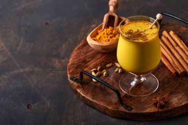 Tarçın çubukları ve ballı zerdeçal altın sütlü latte. Sağlıklı ayurvedic içki. Vejetaryenler için baharatlı Asya doğal detoks içeceği. Boşluğu kopyala.