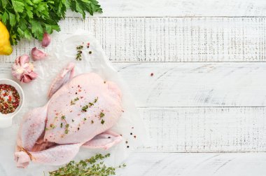 Mutfakta gül biberi, limon, kekik, sarımsak, vişneli domates, sorrel ve tuz yapımında kullanılan malzemelerle dolu çiğ tavuk açık gri kayrak, taş veya beton zemin üzerinde. Üst Manzara. Boşluğu kopyala