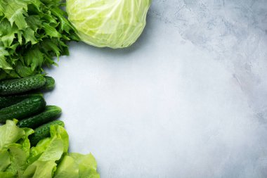 Yeşil sebzeler, lahana, salatalık, dereotu ve marul gri beton arka planda. Mesaj için yer. Model yap. Sağlıklı beslenme ve beslenme kavramı.