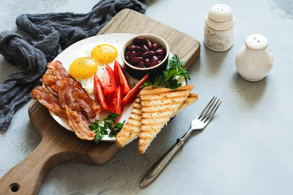 用煎蛋 黑布丁 烤面包和灰色混凝土背景的茶 把传统的英式早餐煎得满满的 顶部视图 — 图库照片