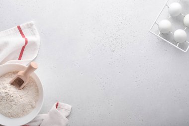 Beyaz mermer masa üzerinde un, yumurta, mutfak aletleri, kap kacak ve kurabiye kalıpları ile fırın arka planı. Üst Manzara. Düz yatış stili. Model.