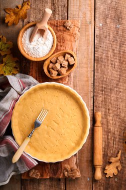 Balkabağı ve yiyecek malzemeleri, baharatlar, tarçın ve mutfak aletleri eski ahşap arka planda. Tatil için ev yapımı pişirme kavramı. Şükran Günü için balkabağı turtası ve kurabiye pişiriyorum..
