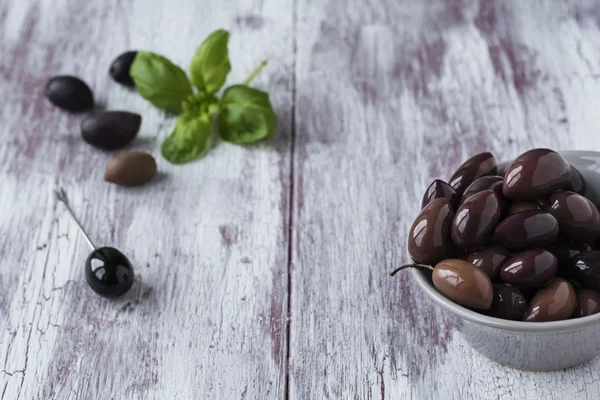 Pickled black olives in a bowl on wooden background. — Stock Photo, Image