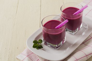 Smoothie made with frozen red berries,milk, and oatmeal in a glasses in wooden background.Selective focus. clipart