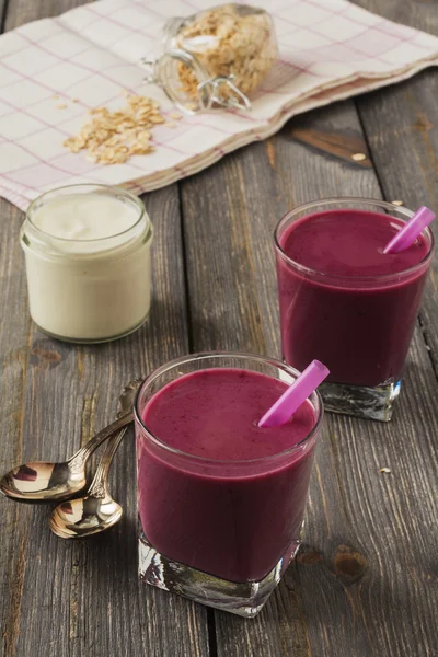 Smoothie made with frozen red berries,milk, and oatmeal in a glasses in wooden background.Selective focus. — Stock Photo, Image