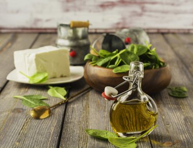Zeytin yağı ile beyaz peynir ve Çiğ ıspanak eski tablo arka plan üzerinde.