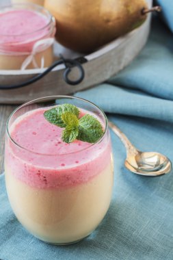 Eski bir ahşap masa arka plan kırmızı geçerli ve nane yaprağı ile armut güler yüzlü. Seçici odak.