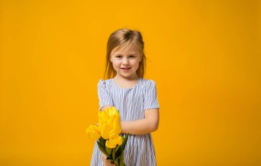 Sarışın küçük bir kız sarı arka planda sarı lale buketi veriyor. Mesaj atabileceği bir yer de var.