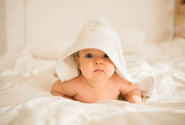 Ένα Κοριτσάκι Λευκή Πετσέτα Μπάνιου Ξαπλώνει Στο Κρεβάτι Και Κοιτάζει — Φωτογραφία Αρχείου