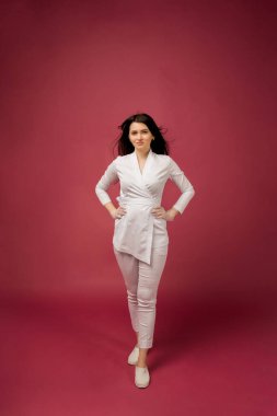 Burgonya arka planında beyaz takım elbiseli, mesaj için yeri olan bir kadın doktor.