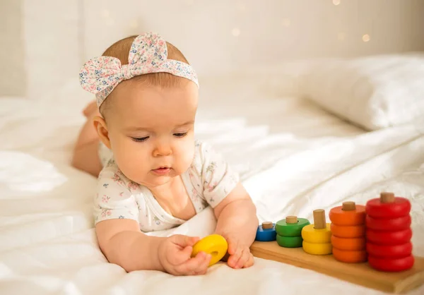 Little Baby Girl Lies Colored Bodysuit Headband Plays Educational Toy — Zdjęcie stockowe