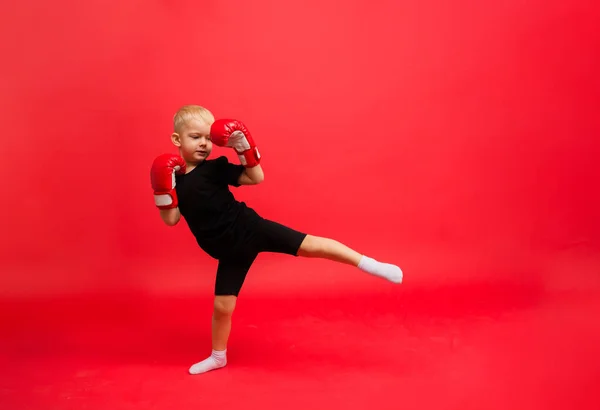 Ein Kleiner Junge Roten Boxhandschuhen Kickt Auf Rotem Hintergrund Mit — Stockfoto