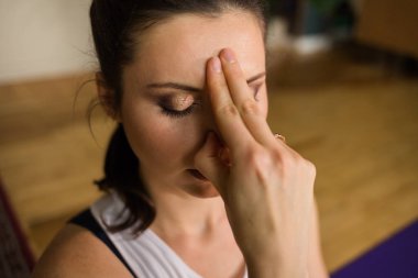 Kadın bir yoga uzmanının burnundan nefes alıp ağzından nefes alıp verişini yakından çek. Nefes alma pratiği. Alternatif tıp