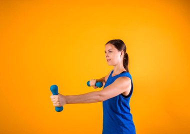 Turuncu arka planda dambılları olan ve metin için yeri olan bir sporcunun yan görüntüsü