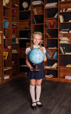 Kütüphanede küresi olan üniformalı güzel bir kız.