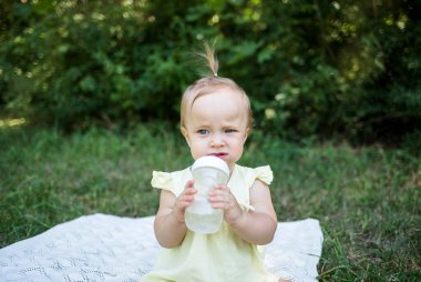Bir çocuk, doğadaki içme kabından su içer.