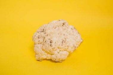 Sarı izole bir zemin üzerinde çürümüş karnabahar ve metin için boşluk.