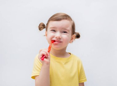 Kız bir diş fırçasıyla dişlerini fırçalar. Diş çürüğü. Dişlerle ilgili bir sorun. Diş ağrısı..