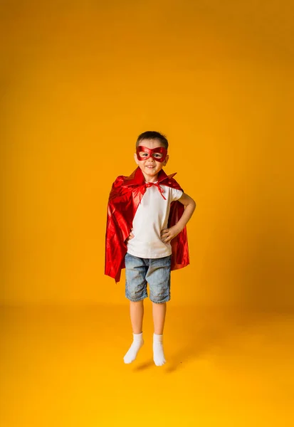 Kleine Jongen Een Held Kostuum Springt Een Gele Achtergrond Met — Stockfoto