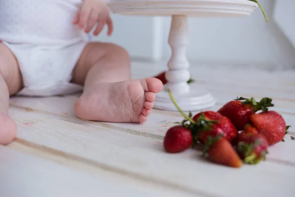 Närbild Ett Barns Fötter Med Jordgubbar Vit Träbakgrund Sommarbakgrund — Stockfoto