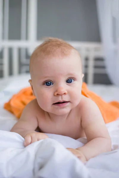 Retrato Bebê Olhos Azuis Deitado Sob Uma Toalha Laranja Cama — Fotografia de Stock