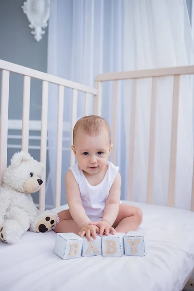 Menino Bodysuit Branco Senta Uma Cama Bebê Com Ursinho Pelúcia — Fotografia de Stock