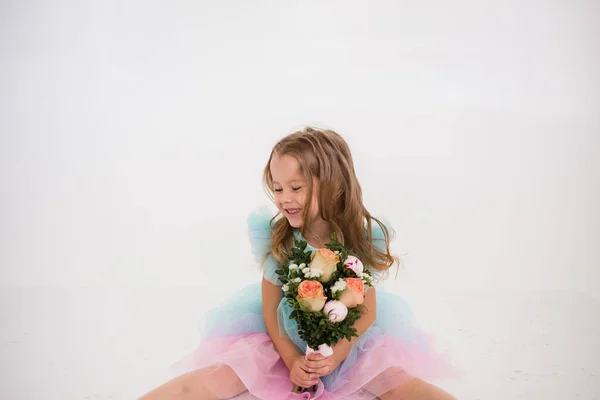 Ein Fröhliches Kleines Blondes Mädchen Sitzt Mit Einem Blumenstrauß Auf — Stockfoto