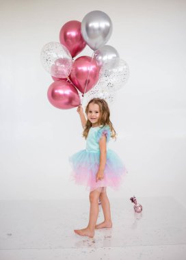 Şenlik elbisesi içinde neşeli küçük bir kız beyaz arka planda mesaj atabileceği bir yerde bir sürü balon tutuyor. Neşeli arkaplan
