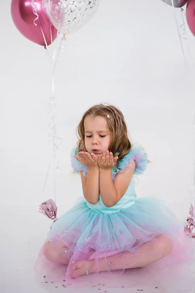 Schöne Kleine Mädchen Einem Festlichen Kleid Sitzt Und Pustet Konfetti — Stockfoto