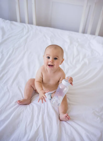 Ein Fröhliches Kleines Mädchen Einer Windel Sitzt Mit Einer Flasche — Stockfoto