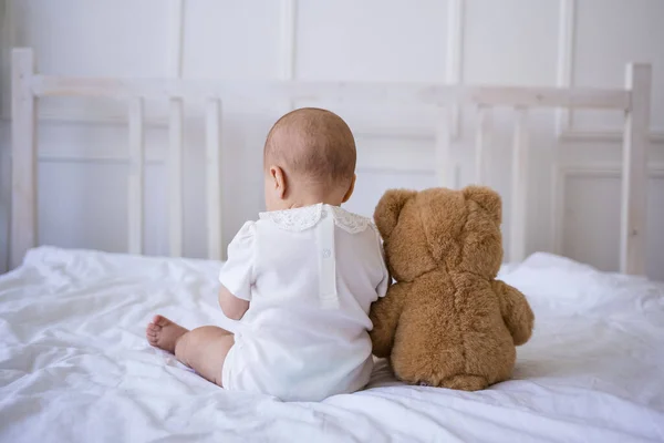 Bebê Menina Está Sentado Com Ela Volta Cama Com Ursinho — Fotografia de Stock
