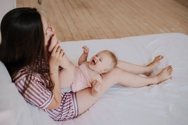 Brunetka Mama Paski Piżama Bawi Się Jej Córka Łóżko Sypialni — Zdjęcie stockowe