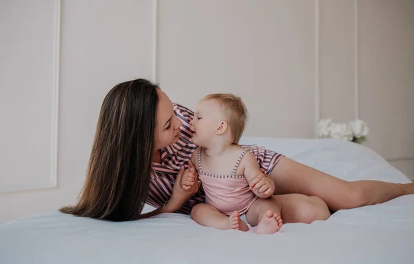 Brunette Mom Striped Pajamas Lying Bed Hugs Her Little Daughter — 스톡 사진